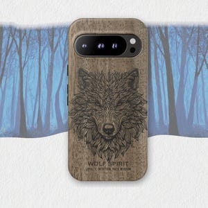 May include: A wooden phone case featuring a detailed illustration of a wolf's face. The case has the words "WOLF SPIRIT" and "LOYALTY, INTUITION, PACK WISDOM" printed on it. The case is brown with a dark brown wolf design.