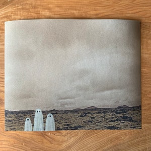 May include: Three white ghosts standing in a field of brown grass with a distant mountain range in the background. The sky is a light gray color.