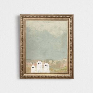 Peut inclure: Une peinture encadr&eacute;e repr&eacute;sentant trois fant&ocirc;mes blancs aux yeux noirs debout en rang devant un paysage bleu clair et brun.