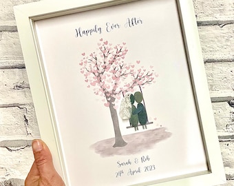 Pode incluir: Uma obra de arte emoldurada com um casal em um balanço sob uma árvore com corações rosas. O texto "Happily Ever After" está no topo da obra de arte. O texto "Sarah & Rob 24th April 2023" está na parte inferior da obra de arte.