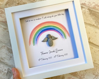 May include: A framed rainbow with a stone angel in the center. The text reads "Look for me in rainbows. I will always be your little boy. Thomas Jacob Barnes 18th February 2022 - 20th February 2022."