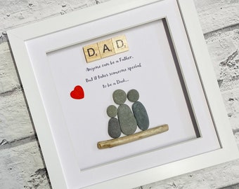 Può includere: Un'opera d'arte in ciottoli incorniciata con una famiglia di quattro persone, un cuore rosso e il testo "D, A, D, Anyone can be a Father. But it takes someone special to be a Dad..."
