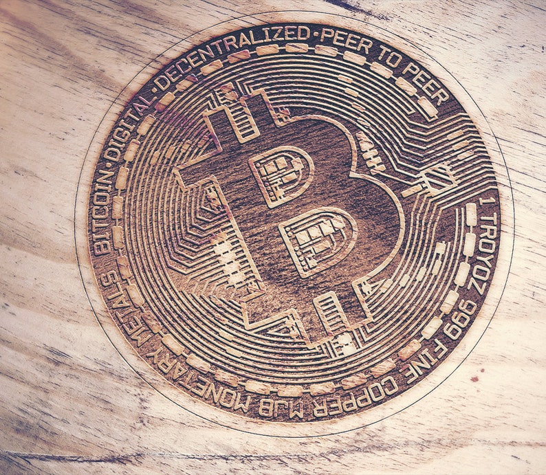 May include: A close-up of a wooden coin with a Bitcoin logo and the text "BITCOIN DIGITAL DECENTRALIZED - PEER TO PEER - 1 TROYOZ 999 FINE COPPER MLB MONEY PAYALS".