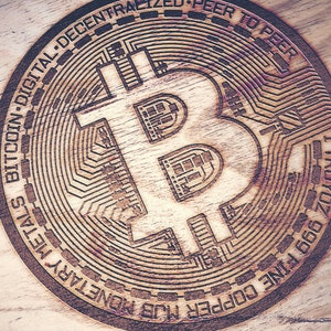 May include: A wooden coin with a Bitcoin logo engraved on it. The coin is inscribed with the words "1 TROYOZ 999 FINE COPPER MUB MONETARY METAL BITCOIN DIGITAL-DECENTRALIZED-PEER TO PEER".