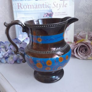 Antik kopparglans kanna med blå och orange dubbelbandsdesign