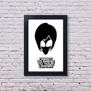 May include: A black framed print featuring a white background with a black silhouette of an alien head and the text I WANT TO SPEAK TO YOUR LEADER in a bold, blocky font. The artwork is centered within the rectangular black frame.