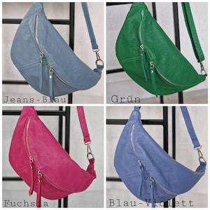 Op de afbeelding: Vier leren heuptassen in verschillende kleuren: jeansblauw, groen, fuchsia en blauw-violet. Elke tas heeft een gebogen vorm, een ritssluiting en een verstelbare riem. De tassen worden gepresenteerd tegen een zwart metalen rek.