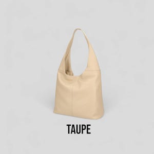 May include: A taupe leather tote bag with a single strap.