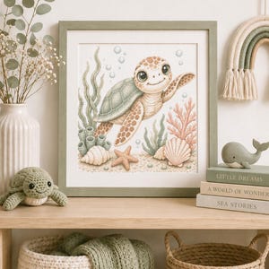 May include: A framed wall art print featuring a cartoon sea turtle swimming underwater among coral, seashells, and seaweed. The illustration uses soft pastel tones of green, peach, and cream, with bubbles floating around the turtle.