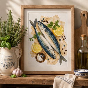 May include: A framed cross-stitch embroidery featuring two blue and silver fish arranged on a light-colored surface with yellow lemon slices, green parsley sprigs, and scattered dark peppercorns, all set against a white fabric background.