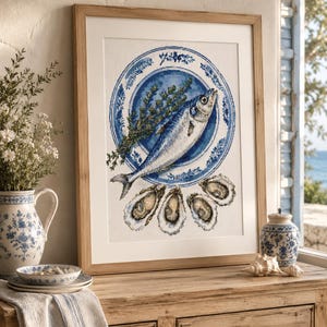 May include: A framed cross-stitch artwork featuring a blue and white patterned plate holding a whole fish and a sprig of green herbs, with four open oysters arranged below the plate, all rendered in detailed embroidery on a light fabric background.