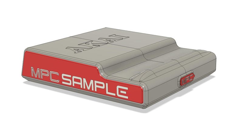 May include: A gray electronic device with the word "AKAI" on top and "MPC SAMPLE" on a red panel. The device has a rectangular shape with a curved top and a small red button on the side.