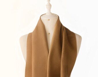 May include: A brown scarf with fringe on a white mannequin.