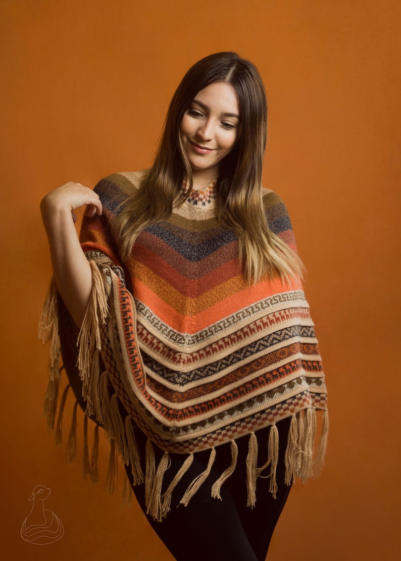 May include: A multi-colored knitted poncho with fringe. The poncho has stripes of orange, red, brown, beige, and black. The poncho has a geometric pattern with a fringe border.