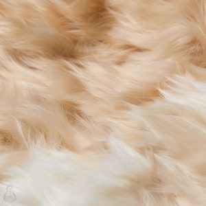 May include: Close-up of a soft, fluffy, cream-colored faux fur fabric. The fur is long and flowing, with a subtle sheen.