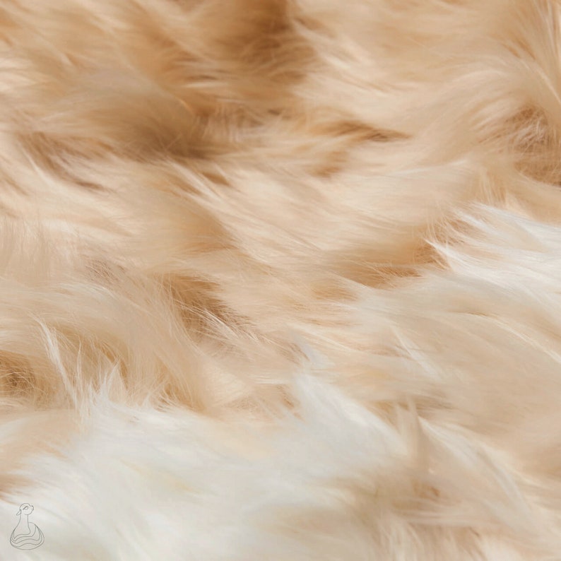 May include: Close-up of a soft, fluffy, cream-colored faux fur fabric. The fur is long and flowing, with a subtle sheen.