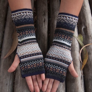 May include: A pair of fingerless gloves with a brown, white, and blue geometric pattern. The gloves are made of a soft, knitted fabric.