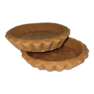 May include: Two brown pie crusts stacked on top of each other. The crusts are fluted and have a slightly rough texture.