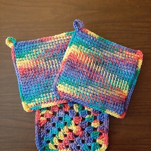 May include: Three crocheted pot holders in a rainbow of colors. The pot holders are made with a variety of stitches and are perfect for protecting your hands from hot surfaces.