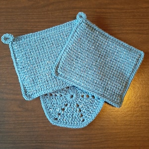 May include: Three blue crocheted pot holders. Two are square with a simple stitch pattern and one is round with a more intricate design.