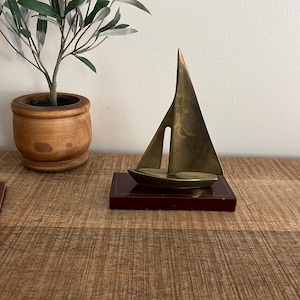 Velero vintage de latón sobre soporte de madera de caoba