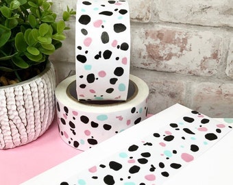May include: Two rolls of white washi tape with a black, pink, and blue polka dot pattern.