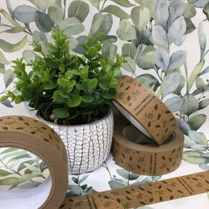 May include: Four rolls of brown paper tape with a leaf pattern and the text "I'm eco-friendly, please recycle me".