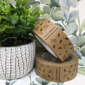 May include: Two rolls of brown paper tape with a leafy pattern and the text "I'm eco-friendly, please recycle me".