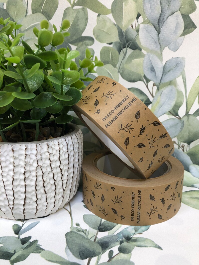 May include: Two rolls of brown paper tape with a leafy pattern and the text "I'm eco-friendly, please recycle me".