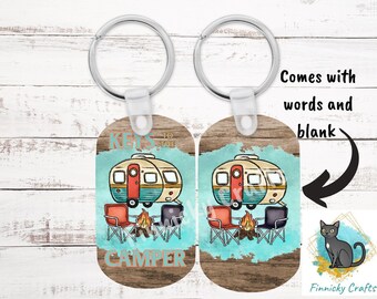 May include: Two oval keychains with silver rings. One features a vintage camper, campfire, and chairs with the text "KEYS TO THE CAMPER" in teal. The other is blank. Both have a wood-grain background and a teal watercolour splash design.