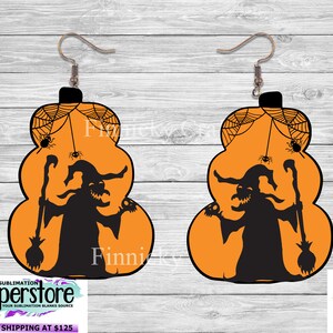 May include: A pair of orange pumpkin-shaped earrings with a black silhouette of a witch holding a broom and a skull. The earrings have a spiderweb design with spiders hanging from the web.