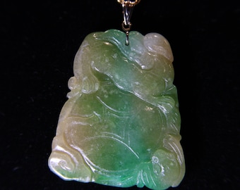 May include: A green and white jade pendant carved with a detailed design. The pendant is attached to a gold chain.