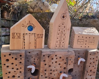 May include: A wooden bee house with three small wooden houses on top. The houses are decorated with carved designs and the words "Welcome". There are several bees flying around the bee house.