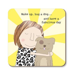 May include: A yellow background with a sunburst pattern. A woman with blonde hair is hugging a brown dog. The text reads "Wake up, hug a dog... and have a fabulous day."
