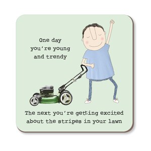 May include: A square coaster with a pale green background. It features a cartoon illustration of a person and a lawnmower. Text reads "One day you're young and trendy. The next you're getting excited about the stripes in your lawn."