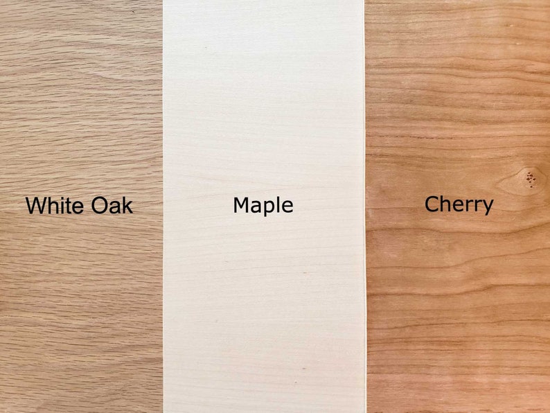 May include: Close-up of three wood samples: white oak, maple, and cherry. The wood grain is visible in each sample.