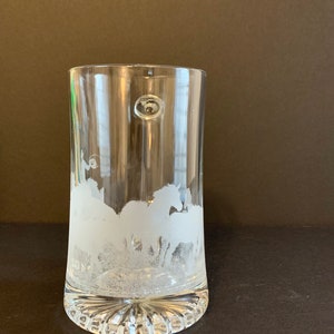Peut inclure: Verre &agrave; boire transparent avec un motif givr&eacute; de chevaux au galop. Le verre a une base arrondie avec des rainures verticales et une petite bulle sur le c&ocirc;t&eacute;. Le motif est grav&eacute; dans le verre, cr&eacute;ant un aspect blanc textur&eacute;.