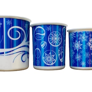 May include: Three blue and white plastic cups with snowflake and winter-themed designs. The cups are different sizes.