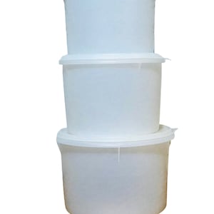 May include: Three white plastic containers stacked on top of each other. Each container has a matching lid. The containers are cylindrical and appear to be empty. The lids have a small tab for easy opening.