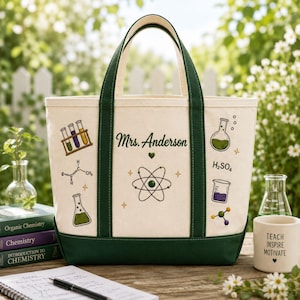 Puede incluir: Un bolso de lona color crema con bordes y asas de color verde oscuro. El bolso presenta gráficos bordados con temática científica que incluyen tubos de ensayo, un vaso de precipitados, un átomo y el texto Mrs. Anderson con fórmulas.