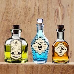 K&ouml;nnte beinhalten: Drei Glasflaschen mit Korkstopfen und Etiketten. Die Flasche links ist gr&uuml;n und tr&auml;gt die Aufschrift "Dragon Blood". Die Flasche in der Mitte ist blau und tr&auml;gt die Aufschrift "Mermaid 100% Pure Tear Drops". Die Flasche rechts ist bernsteinfarben und tr&auml;gt die Aufschrift "Unfiltered Poison".