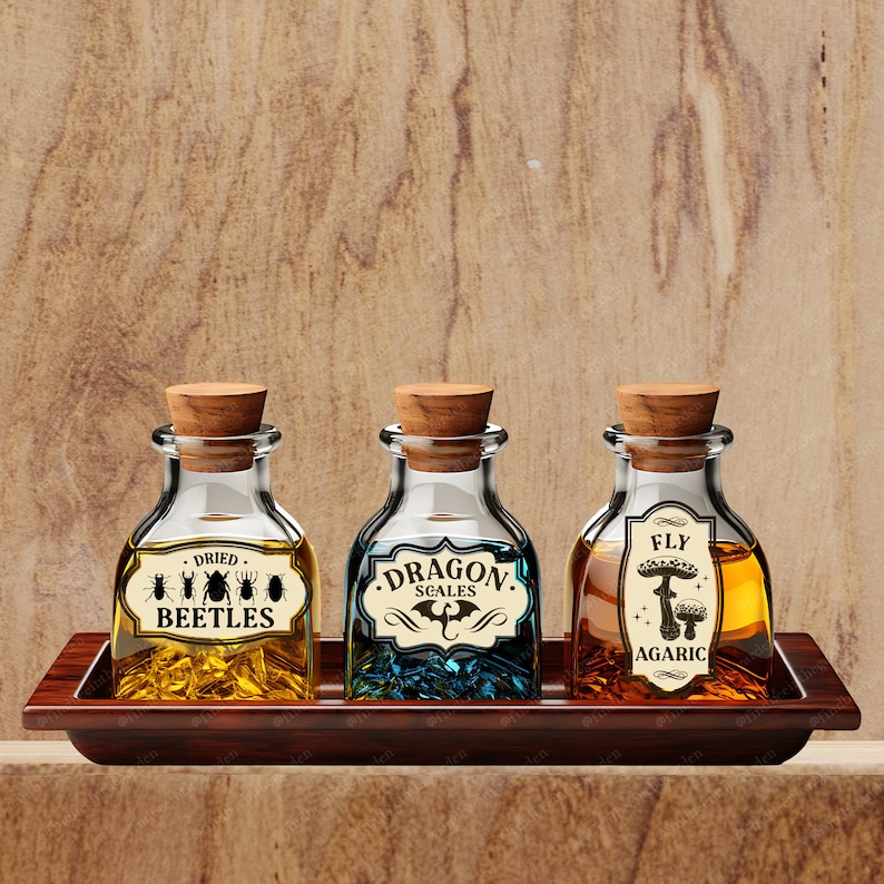 K&ouml;nnte beinhalten: Drei Glasflaschen mit Korkstopfen und Etiketten auf einem Holztablett. Die Etiketten lauten "Dried Beetles", "Dragon Scales" und "Fly Agaric".