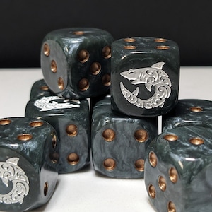 May include: A collection of dark gray marbled dice with copper-colored pips. Each die features a silver-toned engraved shark icon on the face representing the number one, with a swirling, intricate pattern integrated into the shark design.