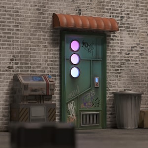 May include: A green metal door with three circular, illuminated lights, set in a brick wall. The door has graffiti and a small awning. A metal trash can and a machine with graffiti are also visible.