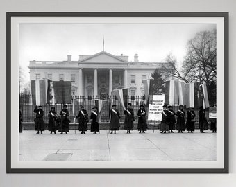 May include: Black and white photograph of a group of women holding banners and protesting in front of the White House. The banners read "Mr. President How Long Must Women Wait For Liberty?"