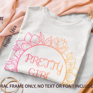 May include: A white t-shirt featuring a floral design and the text "PRETTY GIRL" in a pink and orange gradient. The floral design is a circle of magnolia flowers and leaves.