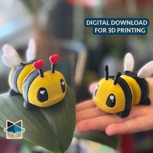 Puede incluir: Dos figuras de abeja de peluche con cuerpos amarillos y negros, alas blancas y antenas en forma de corazón. Una abeja descansa sobre una hoja verde, la otra se sostiene en una mano. El texto dice "DESCARGA DIGITAL PARA IMPRESIÓN 3D".