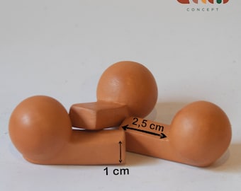 May include: Three terracotta-colored ceramic spheres, each with a flat, rectangular base. The spheres are arranged in a triangular shape, with the bases of two spheres forming a line. The bases are 1 inch apart, and the spheres are 2.5 inches apart.
