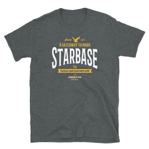 May include: A dark heather grey t-shirt with a white graphic design that says "Since 2021 A Gateway to Mars Starbase TX Formed and Saturated with An American Original".
