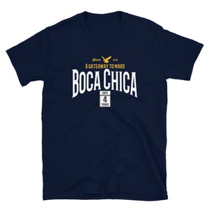 May include: Navy blue t-shirt with white text that reads "Boca Chica" and "A Gateway to Mars" with a yellow bird logo. The text "since 2019" and "East Texas 4" are also included.
